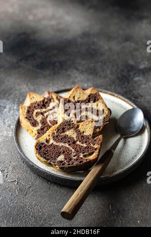 Tre fette di torta zebra su un piatto con il cucchiaio, spazio copia, isolato Foto Stock