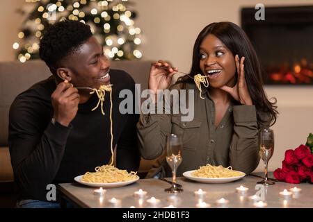 Sposi neri che mangiano pasta per celebrare San Valentino a casa Foto Stock