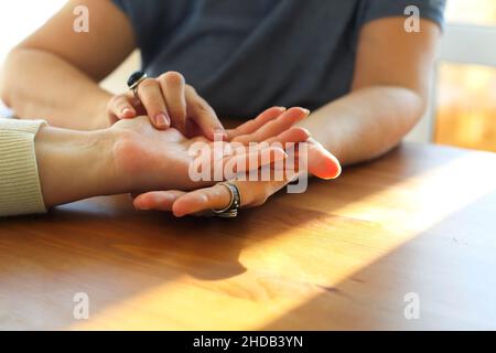 Sessione di Chiromancy. Donna che visita palmistry esperto, scatto ritagliato. Fortune Teller guardare la mano femminile, leggere il futuro, analizzare le linee di vita sulla palma Foto Stock