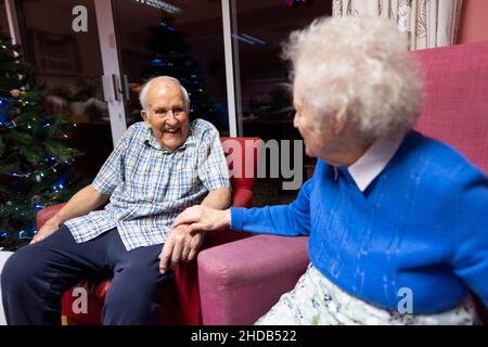 Coppie anziane negli anni ottanta seduti insieme nella loro casa di cura residenziale, Inghilterra, Regno Unito Foto Stock
