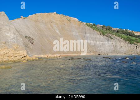 Ripidi pendii di argilla blu, con detriti che formano la striscia costiera a Xatt l-Ahmar, Ghajnsielem, Gozo Foto Stock