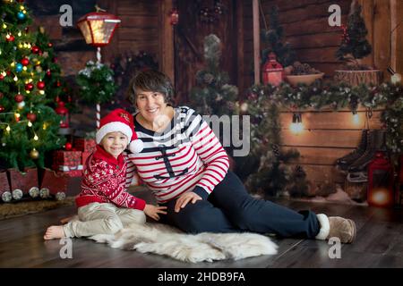 Nonna e bambino, seduti sul pavimento insieme a Natale, accogliente atmosfera di casa Foto Stock