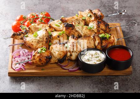 Kebab o shashlik di pollo alla griglia su spiedini da vicino su tavola di legno. Orizzontale Foto Stock