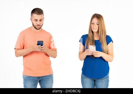 Una giovane coppia su sfondo bianco che guarda lo smartphone. Foto Stock