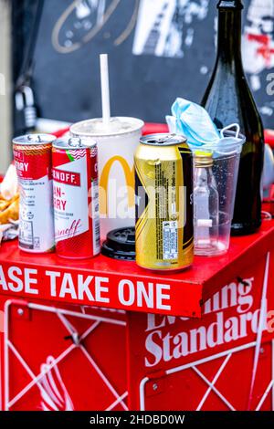 Londra Inghilterra UK Gennaio 02 2022, pile di lattine vuote usate bottiglie e cibo lasciato sul giornale Stand Waterloo Station London Foto Stock