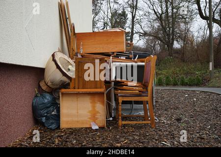 Mucchio ingombrante di rifiuti di fronte ad un muro di casa Foto Stock