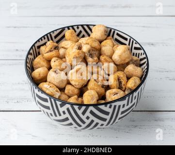 Canjica, popcorn hominy o bianco, popcorn dolce in una ciotola sopra tavola di legno. Foto Stock