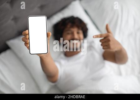 Uomo indiano che punta allo smartphone con schermo vuoto Foto Stock