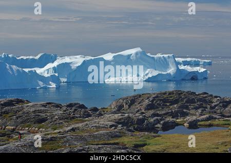 Segnavia giallo, vista della barca di fronte a enormi iceberg, Disko Bay, Sermermuit, Ilulissat, Artico, Groenlandia, Danimarca, Nord America Foto Stock