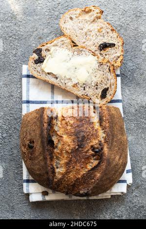 Pane fresco di pasta di origine affettato con albicocche secche e prugne secche su sfondo grigio. Primo piano. Foto Stock