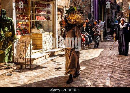 L'uomo porta il pollo vivo e osa guardare i gioielli d'oro, Old City Bazaar, Luxor, Tebe, Egitto, Luxor, Tebe, Egitto, Africa Foto Stock