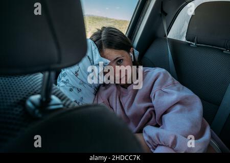 Teen girl rilassarsi sul retro dell'auto durante un viaggio su strada Foto Stock