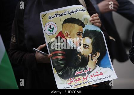 Nablus, Cisgiordano, Palestina. 5th Jan 2022. I palestinesi detengono bandiere e manifesti del prigioniero palestinese Hisham Abu Hawash, che è in sciopero della fame per 141 giorni nelle carceri israeliane. Centro di Nablus nella West Bank occupata. Credit: Nasser Ishtayeh/ZUMA Wire/Alamy Live News Foto Stock