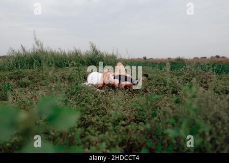 Una coppia di nozze amorevole all'aperto tra le braccia dell'altro in un prato verde Foto Stock