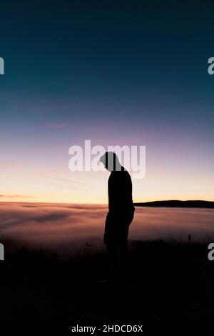 Silhouette di un ragazzo da una montagna Foto Stock