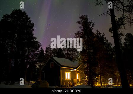 Europa, Finnisch-Lappland, Beleuchtete Hütte vor Nordlichter Foto Stock