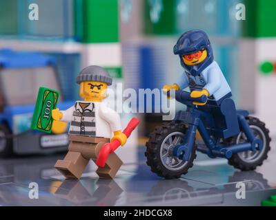 Tambov, Federazione Russa - 04 gennaio 2022 una minifigura ufficiale di polizia Lego che è su una bicicletta che insegue una minifigura ladro Lego. Foto Stock