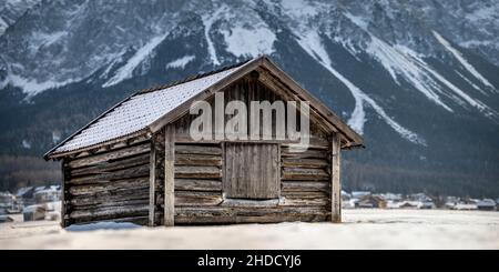 Fienile in legno molto vecchio con neve sul tetto in inverno a Tiroler Zugspitz Arena Foto Stock