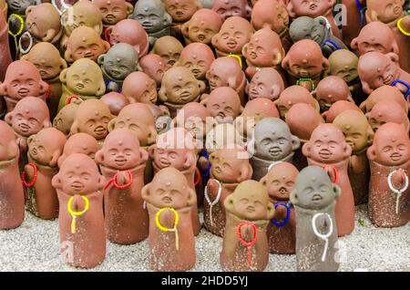 Statuette multiple che onorano una certa divinità nel piccolo tempio situato sul Monte Misen a Miyajima, Giappone Foto Stock