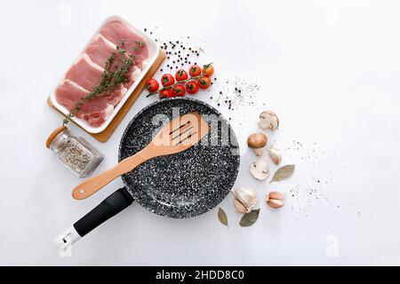 Padella in marmo nero con prodotti su sfondo grigio chiaro, vista dall'alto Foto Stock