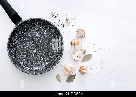 Padella in marmo nero con prodotti su sfondo grigio chiaro, vista dall'alto Foto Stock