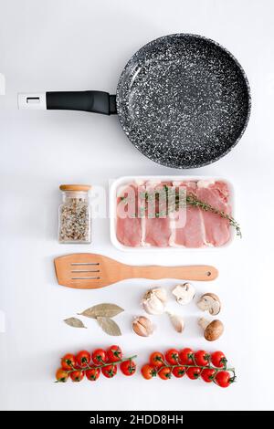 Padella in marmo nero con prodotti su sfondo grigio chiaro, vista dall'alto Foto Stock