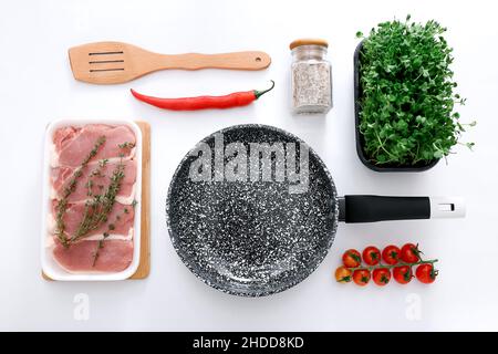 Padella in marmo nero con prodotti su sfondo grigio chiaro, vista dall'alto Foto Stock