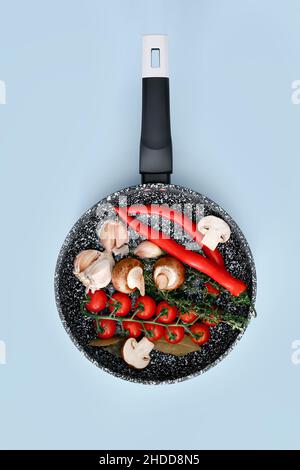 Padella in marmo nero con prodotti su sfondo blu, vista dall'alto Foto Stock