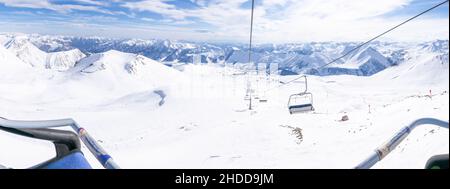 Vista dei sedili anteriori sulle seggiovie in inverno con sfondo delle montagne del caucaso Foto Stock