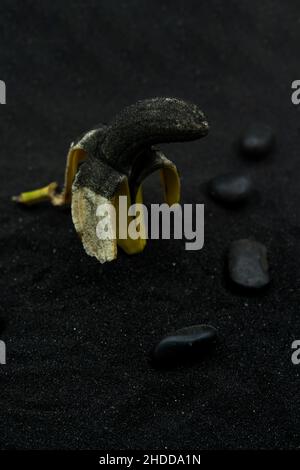 Banana aperta coperta di cenere su cenere vulcanica. Eruzione di la Palma, Spagna Foto Stock