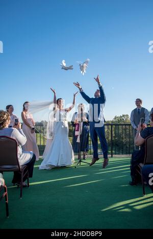 Minnesota, Stati Uniti. Sposa e sposo rilasciare colombe bianche nel loro giorno di nozze a destra dopo aver detto i loro voti di nozze Foto Stock