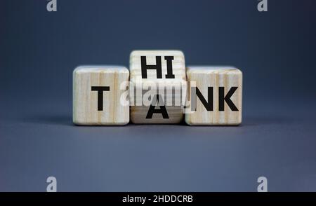 Think Tank. L'uomo d'affari trasforma un cubo di legno e cambia il serbatoio di parola per pensare. Bella tabella grigia, sfondo grigio, spazio di copia. Business e. Foto Stock