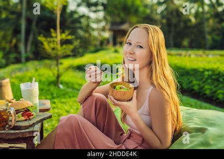 Bella giovane donna che mangia insalata di verdure fresche. Perdita del concetto di peso Foto Stock