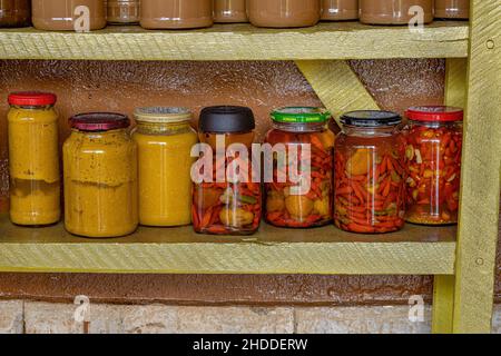 Itaja, Goias, Brasile - 12 24 2021: Pasta di pequi in scatola e pepe in scatola in vasetti su una mensola Foto Stock