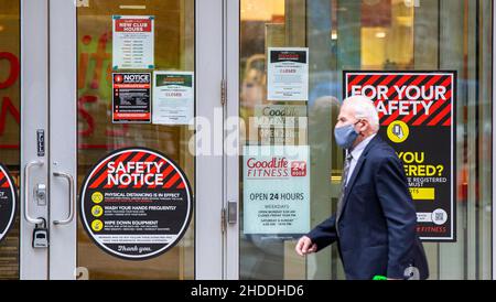 Toronto, Canada. 5th Jan 2022. Un uomo che indossa una maschera facciale cammina davanti ad un club di fitness chiuso a Toronto, Ontario, Canada, il 5 gennaio 2022. In risposta alle tendenze recenti che mostrano un aumento allarmante delle ospedalizzazioni COVID-19, il governo dell'Ontario ha cominciato ad imporre le misure per smussare la trasmissione del virus per almeno 21 giorni, compreso palestre di chiusura, teatri, cinema, musei, gallerie e divieto di cenare al coperto presso i ristoranti. Credit: Zou Zheng/Xinhua/Alamy Live News Foto Stock