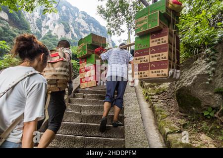 HUA SHAN, CINA - 4 AGOSTO 2018: Porter alle scale che conducono alle cime del monte Hua Shan, Cina Foto Stock