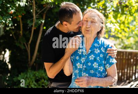 nonna molto vecchia e nipote adulto. Foto Stock