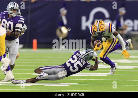 LSU Tigers quarterback Jontre Kirklin (13) evita l'attacco di Kansas state Wildcats difesa indietro Ekow Boye-Doe (25) durante il Texas Bowl di TaxAct, Foto Stock