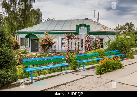 Casa e panchine vicino alla Cattedrale della Santissima Trinità a Karakol, Kirghizistan Foto Stock