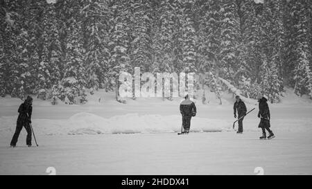 Lago Louise, Canada - Dicembre 22 2021: Persone che camminano e giocare a bufale sul lago ghiacciato Louise in Alberta Foto Stock