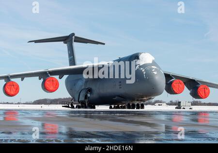 Una C-5M Super Galaxy coperta di neve si trova sulla linea di volo alla base dell'aeronautica di dover, Delaware, 4 gennaio 2022. Inverno Storm Frida ha lasciato cadere otto pollici di neve sulla base, iniziando le prime operazioni di rimozione della neve dell'anno. (STATI UNITI Air Force foto di Roland Balik) Foto Stock