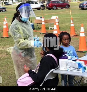 Apopka, Stati Uniti. 05th Jan 2022. Un operatore sanitario raccoglie un campione di tampone nasale da una donna in un sito di test COVID-19 a Edwards Field in Apopka, Florida, mentre la variante Omicron si surge in Florida e in tutto il paese. I siti di test nell'area di Orlando stanno raggiungendo la capacità su base giornaliera, come la Florida ha aggiunto oltre 85.000 nuovi casi COVID-19 questo fine settimana scorso, dopo una settimana record di infezioni. Credit: SOPA Images Limited/Alamy Live News Foto Stock