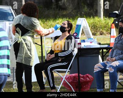 Apopka, Stati Uniti. 05th Jan 2022. Un operatore sanitario raccoglie un campione di tampone nasale da una donna in un sito di test COVID-19 a Edwards Field in Apopka, Florida, mentre la variante Omicron si surge in Florida e in tutto il paese. I siti di test nell'area di Orlando stanno raggiungendo la capacità su base giornaliera, come la Florida ha aggiunto oltre 85.000 nuovi casi COVID-19 questo fine settimana scorso, dopo una settimana record di infezioni. Credit: SOPA Images Limited/Alamy Live News Foto Stock