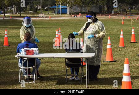 Apopka, Stati Uniti. 05th Jan 2022. Gli operatori sanitari raccolgono campioni di tamponi nasali da persone in un sito di test COVID-19 a Edwards Field ad Apopka, Florida, mentre la variante Omicron si surge in Florida e in tutto il paese. I siti di test nell'area di Orlando stanno raggiungendo la capacità su base giornaliera, come la Florida ha aggiunto oltre 85.000 nuovi casi COVID-19 questo fine settimana scorso, dopo una settimana record di infezioni. Credit: SOPA Images Limited/Alamy Live News Foto Stock