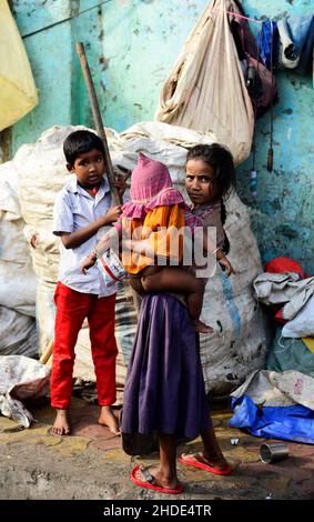 Bambini locali che vivono in piccole case povere sul marciapiede di Mumbai, India. Foto Stock