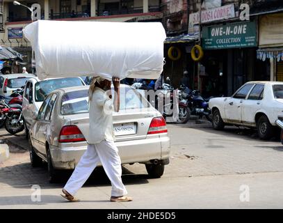 Trasporto di carichi pesanti sulla testa. Mumbai, India. Foto Stock