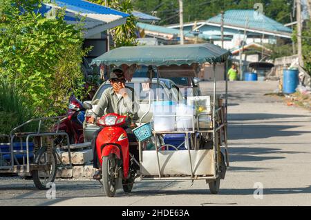 Venditore di strada sulla sua moto in una strada villaggio a Klong Dan, Samut Prakan Provincia di Thailandia Foto Stock