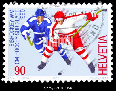 MOSCA, RUSSIA - 4 NOVEMBRE 2021: Francobollo stampato in Svizzera mostra giocatori di hockey su ghiaccio, edizione pubblicitaria serie, circa 1990 Foto Stock