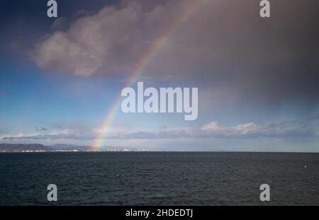 arcobaleno sopra il cielo di mare che si raduna dopo la tempesta Foto Stock