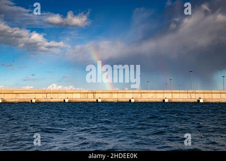 arcobaleno sopra il cielo di mare che si raduna dopo la tempesta Foto Stock